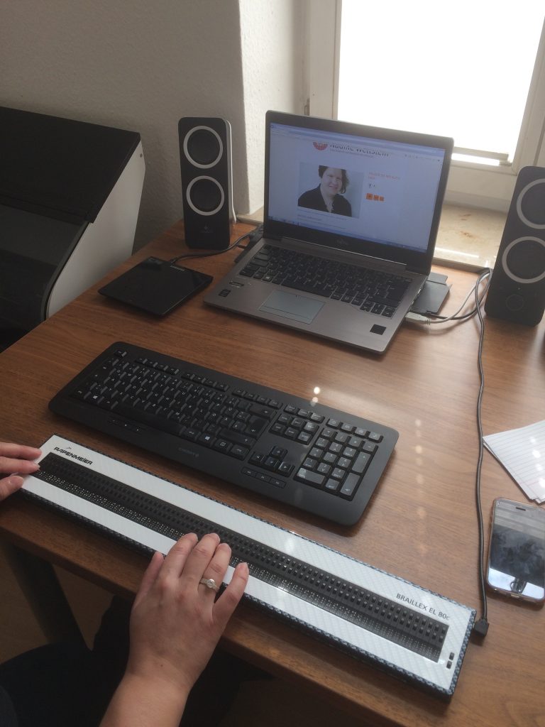 Aufgeklappter Laptop, externe Tastatur und Braillezeile